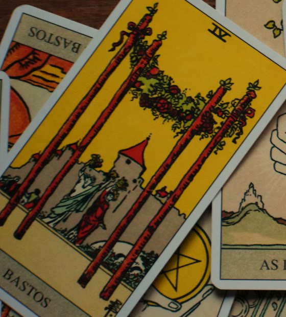 Tarot cards spread across a candlelit table