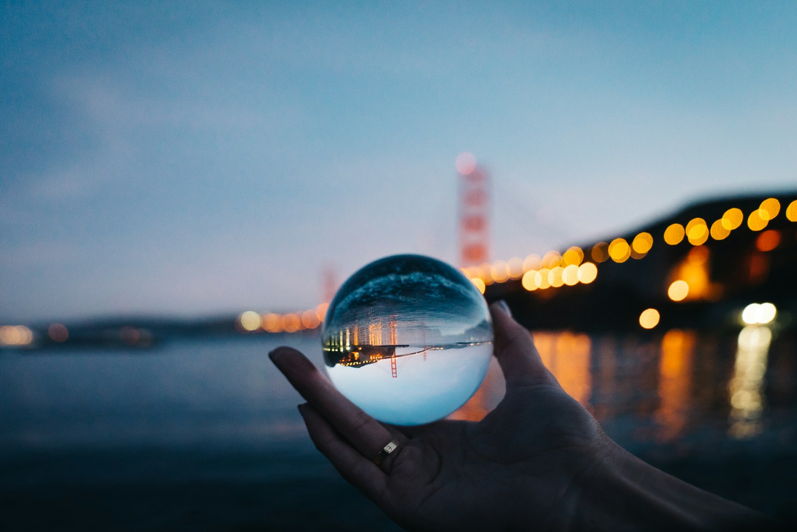 A crystal ball held up against evening lights